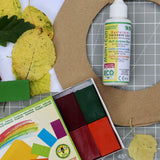 OkoNorm solvent free all purpose craft glue placed on a table amongst other craft supplies.