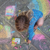 Child drawing on paving slabs with the Okonorm chunky chalks. 