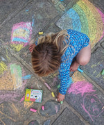 Child drawing on paving slabs with the Okonorm chunky chalks. 