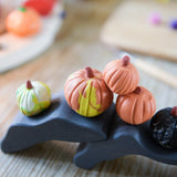 Pumpkins made from OkoNorm modelling clay placed on wooden toys.