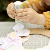 Child using the OkoNorm solvent free all purpose craft glue placing it one the back of paper leaf rubbings.