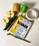 Pack of OkoNorm 12 felt tip pens placed besides Okonorm paints, Babipur tapes and a cut apple.