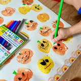 Child using the green pen from the OkoNorm 12 felt tip pens  to paint details on pumpkin prints.