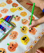 Child using the green pen from the OkoNorm 12 felt tip pens  to paint details on pumpkin prints.