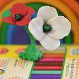 White and red poppy created from OkoNorm modelling clay, placed on the back. 