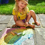 Child drawing a rainbow on slabs with the Okonorm chalks. 