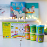 OkoNorm finger paints in 6 unicorn  colours stacked on a table with the packaging box behind them with an Ostheimer unicorn wooden toy figure placed on top.  