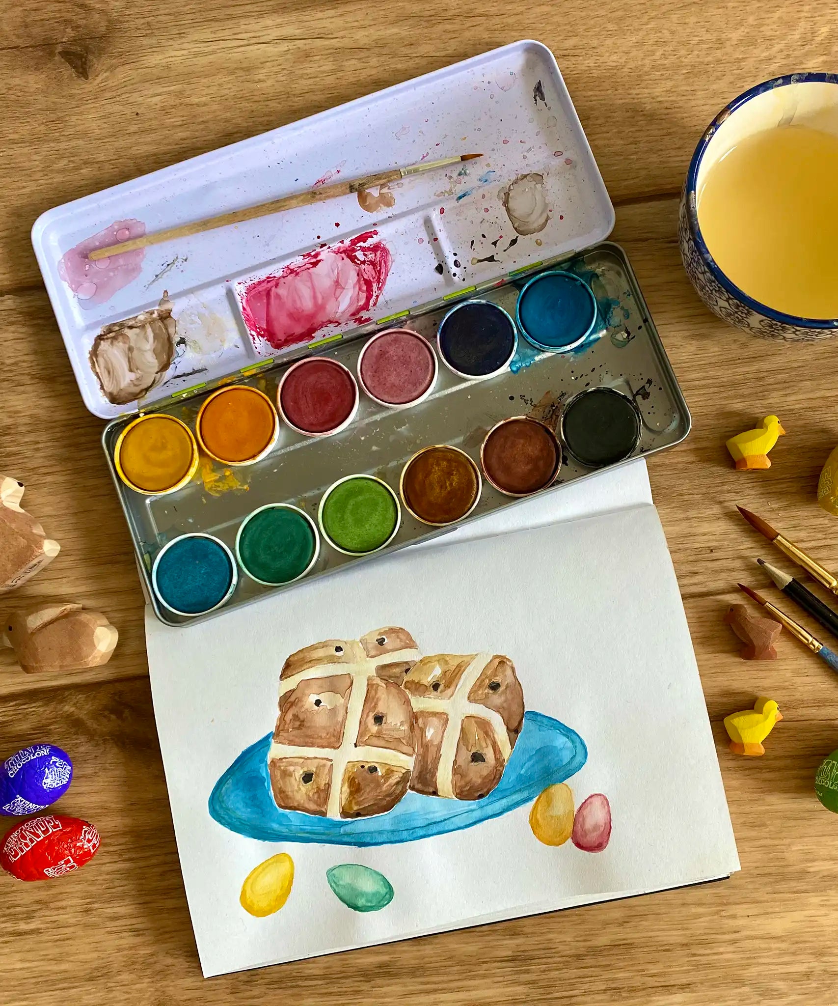 Watercolour hot cross buns painting created using the Okonorm 12 colour watercolour paints in a travel tin.
