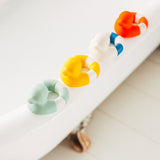 row of Oli & Carol Flo The Floatie Ducks on the side of a bath