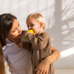 A child chewing on an Oli & Carol Lemon Rattle Teether