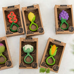 Collection of six Oli & Carol Rattle Teether Toys pictured in their cardboard packaging boxes