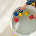 Oli & Carol X Bauhaus Movement Floating Geometric Blocks pictured floating in a metal tub full of water