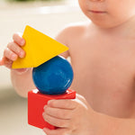 Child holding the Oli & Carol X Bauhaus Movement Floating Geometric Blocks which have water on them
