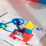 Oli & Carol X Bauhaus Movement Floating Geometric Blocks pictured on a sheet of painted paper