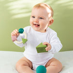 Baby playing with Oli & Carol X Bauhaus Movement Floating Geometric Blocks in Pastel colours with a teething ring in other hand
