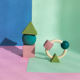 Oli & Carol X Bauhaus Movement Floating Geometric Blocks in Pastel colours and teething ring pictured on a pastel pin