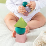 baby playing with teething ring with the Oli & Carol X Bauhaus Movement Floating Geometric Blocks in Pastel colours in front of them
