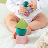 baby playing with teething ring with the Oli & Carol X Bauhaus Movement Floating Geometric Blocks in Pastel colours in front of them