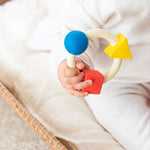 Baby clutching onto the Oli & Carol X Bauhaus Movement Teething Ring
