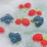 Oli and carol eco-friendly rubber raspberry and blueberry toys floating in some bubbly bath water
