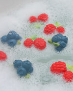 Oli and carol eco-friendly rubber raspberry and blueberry toys floating in some bubbly bath water