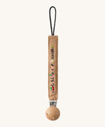 Oli & Carol Cool Kids Pacifier Clip, the words cool kids eat healthy written on a beige canvas with vegetable embroidery detail
