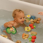 Child playing in a bath with the oli and carol natural rubber