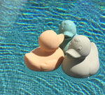 Three Oli & Carol Elvis The Duck Bath Toys floating in a swimming pool