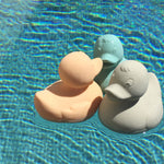Three Oli & Carol Elvis The Duck Bath Toys floating in a swimming pool