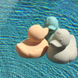 Three Oli & Carol Elvis The Duck Bath Toys floating in a swimming pool