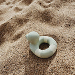 Oli & Carol Flo The Floatie Mint colour duck pictured on sand