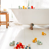 Oli & Carol Flo The Floatie Duck bath toys in various colours pictured in a bathroom