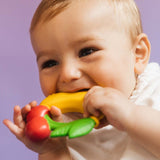 A baby chewing on the Oli & Carol Natural Rubber Fruit Teething Ring.