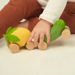 A child wheeling the Oli & Carol Lou the Lemon car across the ground