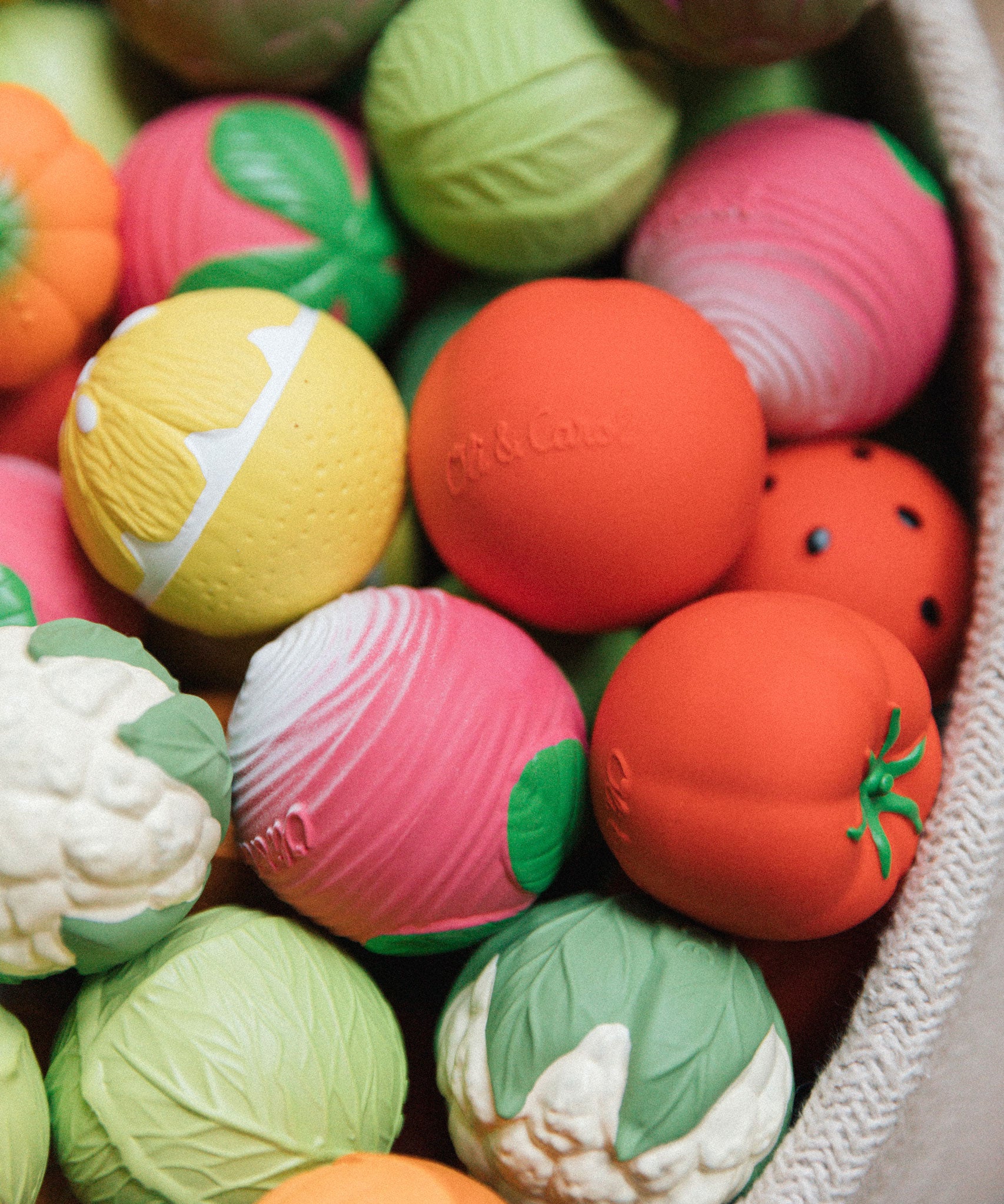 A collection of Oli & Carol fruit and vegetable baby sensory balls 