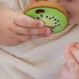Baby clutching and chewing the Oli & Carol Jose Antonio The Kiwi Mini Baby Teether
