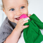 Close up of a baby holding the Oli & Carol natural rubber radish baby teether in it's mouth