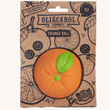Oli & Carol Natural Rubber Baby Ball - Orange in it's card packaging sleeve on a plain background. 