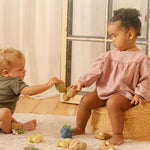 Girl and boy playing with the oli and carol natural rubber soft teething toys