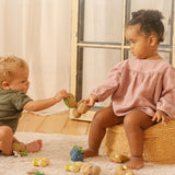Girl and boy playing with the oli and carol natural rubber soft teething toys