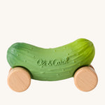 Oli & Carol Pepino The Pickle Baby Car. A fun green pickle car with a with wooden wheels on a cream background