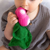 Close up of a young child holding the Oli & Carol Ramona radish doudou baby toy up to it's mouth
