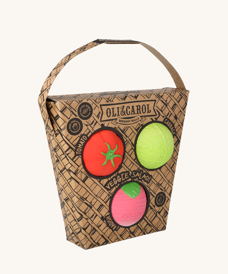 Oli & Carol Veggie Salad Baby Sensory Balls in their basket shaped cardboard packaging, a tomato, cabbage and a radish