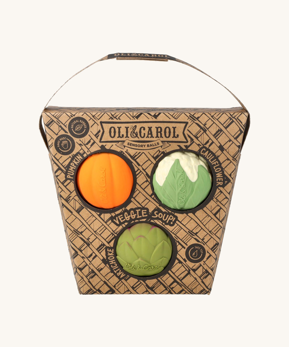 Oli & Carol Vegetable soup Baby Sensory Balls in their basket shaped cardboard packaging, a pumpkin, cauliflower and an artichoke. 