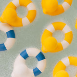 Yellow coloured Oli & Carol Flo The Floatie Ducks in bubbly bath water