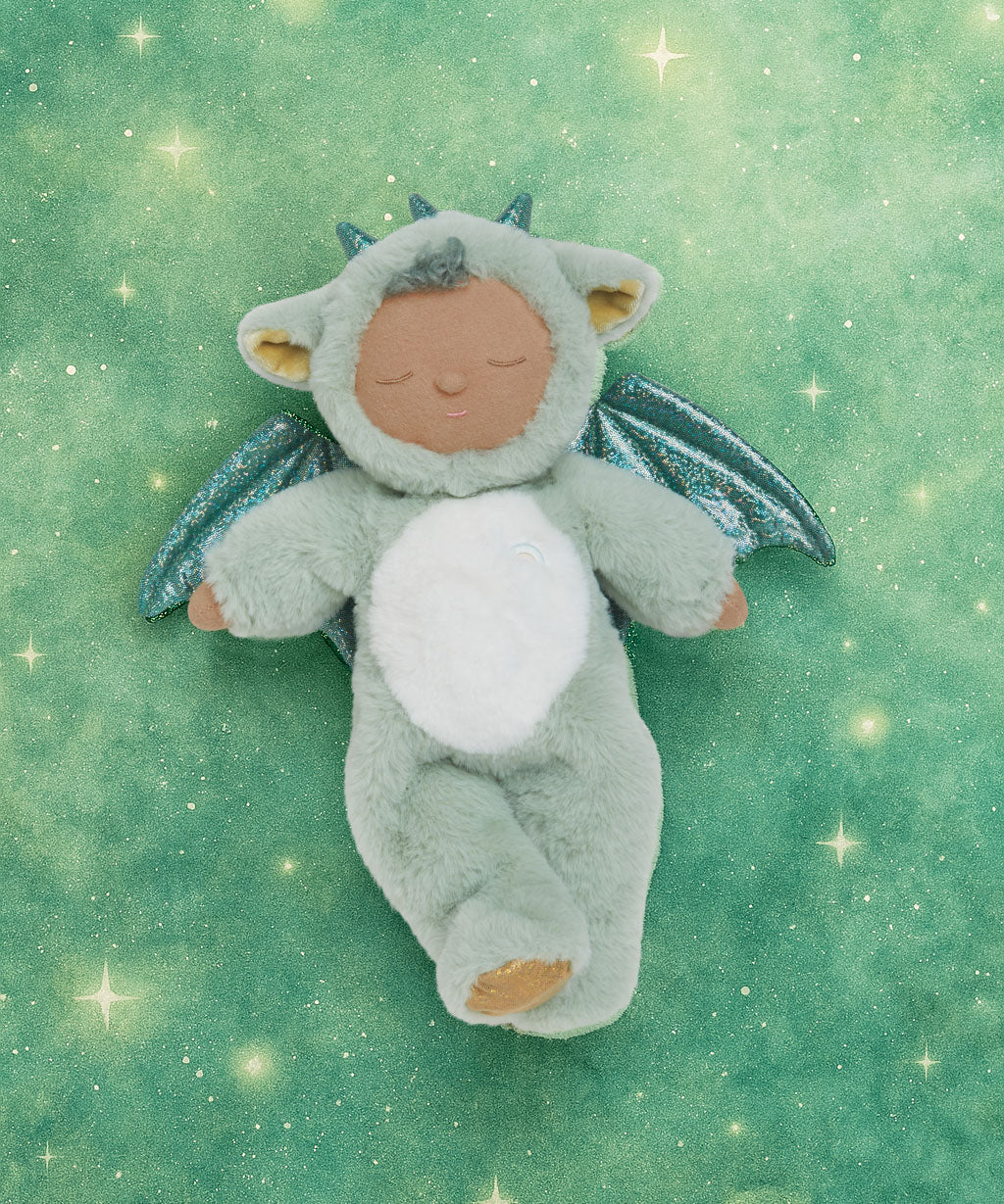 Olli Ella Ash cozy dragon dinkum doll posing against a green dreamy starry background.