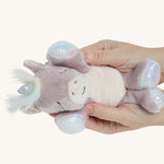 Hands holding the baby unicorn toy for size reference