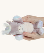 Hands holding the baby unicorn toy for size reference