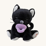 A Olli Ella Kit binky kitten doll sitting with the purple magnetic pacifier in the mouth. This cute fluffy toy doll is available at Babipur