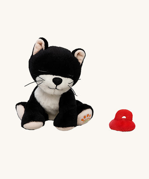 A sitting Olli Ella Kit binky kitten doll available at Babipur. This cute black fluffy kitten doll has light pink paws, whiskers and comes with a red magnetic pacifier.
